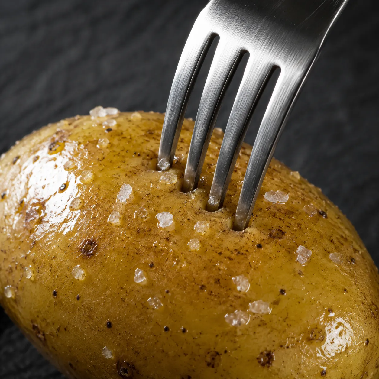 Pricking an oiled potato with a fork before air frying