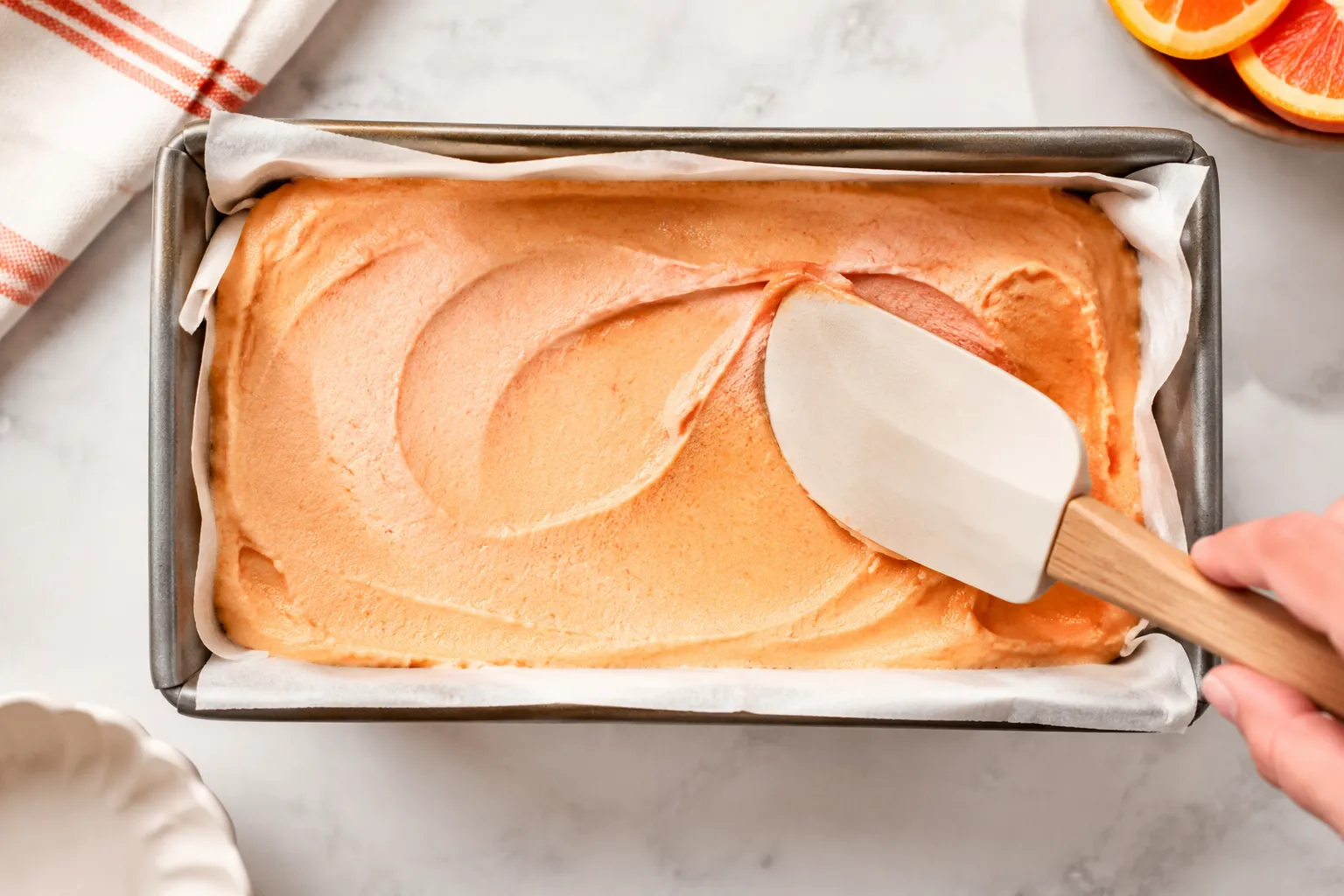 Spreading homemade sherbet into a loaf pan before freezing