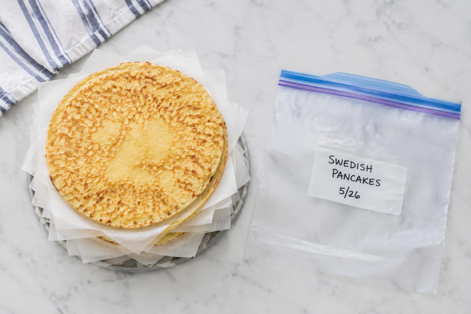Swedish pancakes stacked with parchment paper for freezer storage