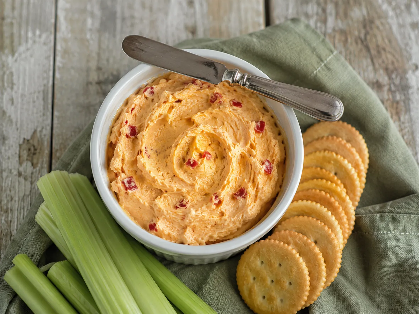 Finished pimento cheese recipe in a serving crock with crackers