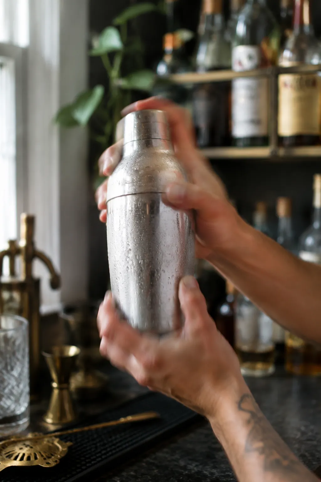 Shaking a Tom Collins cocktail in a stainless steel shaker