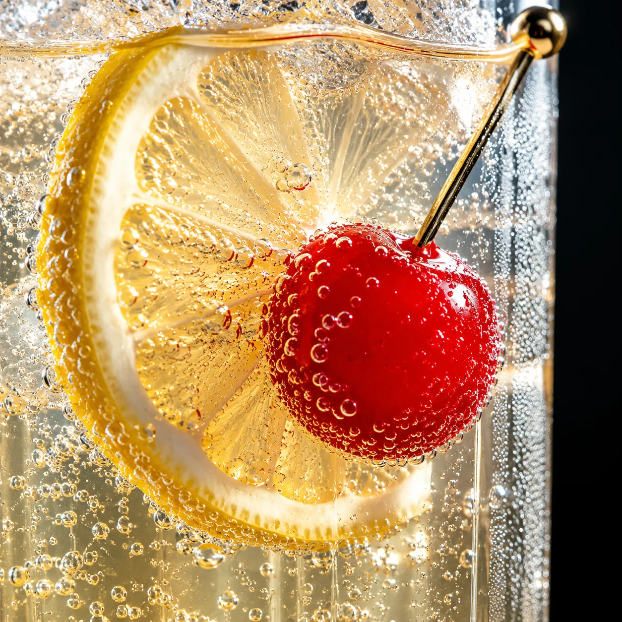 Close-up of bubbles and lemon garnish in a Tom Collins recipe
